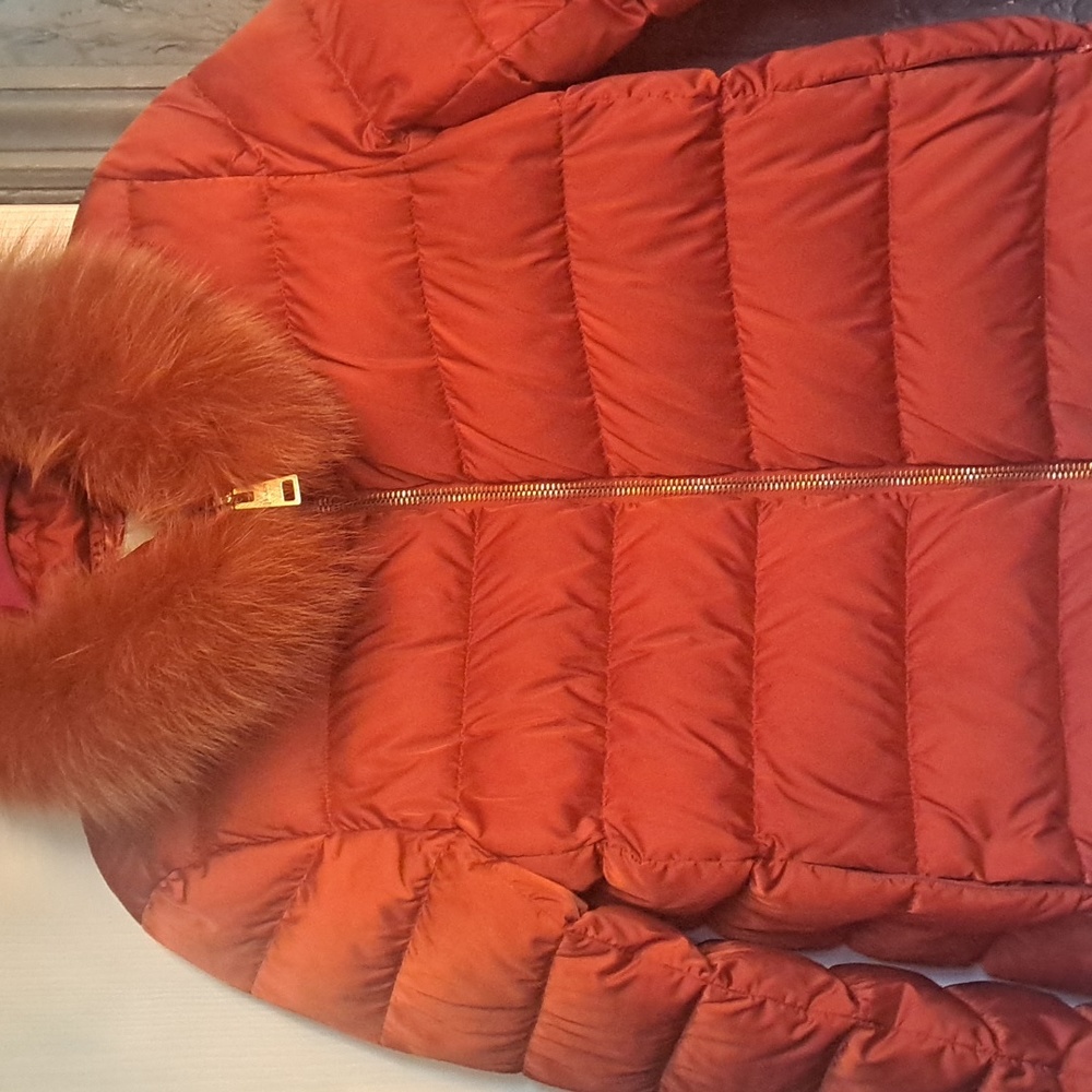 Herno brand burnt orange jacket with fur collar.  Size small Two zip pockets.